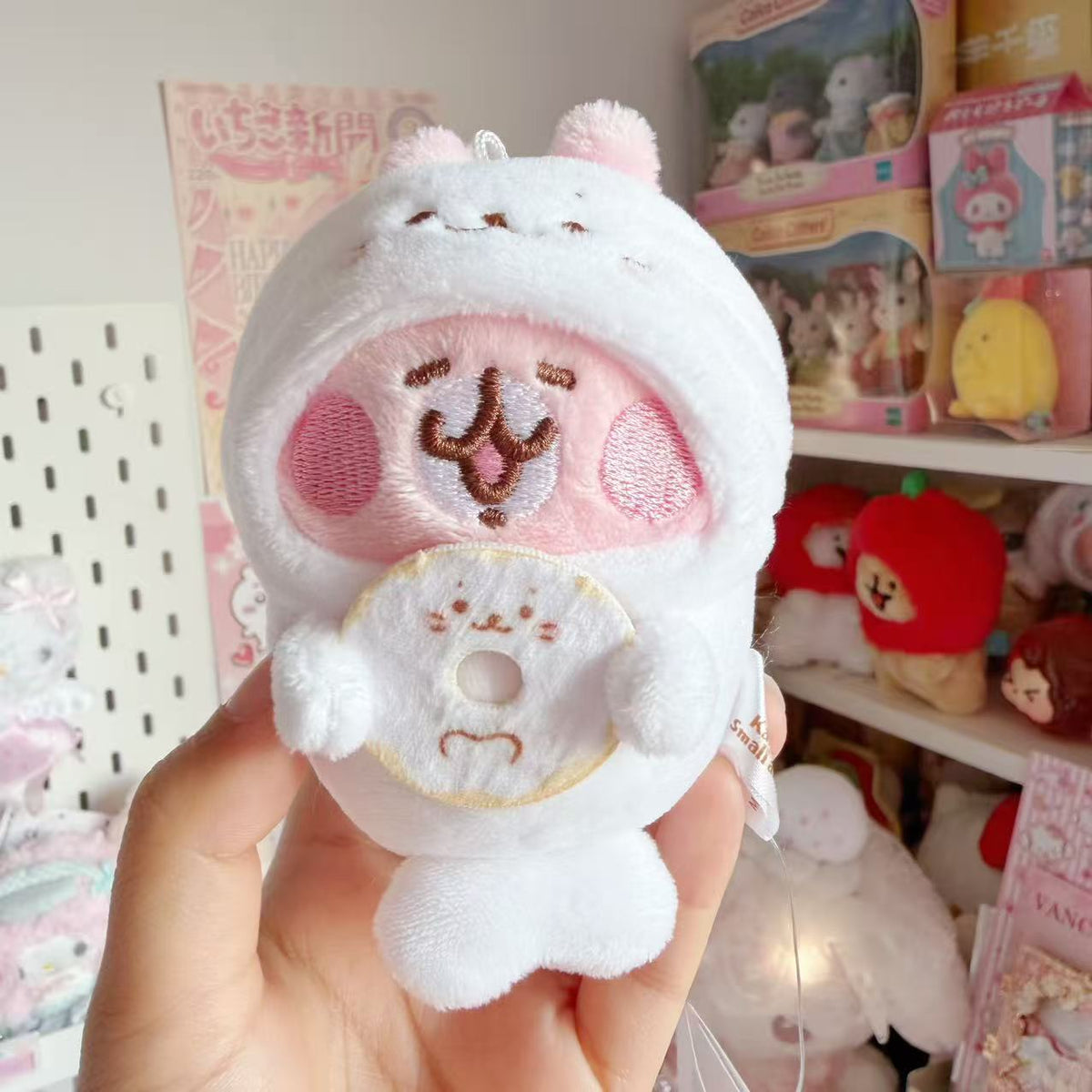 Kanahei’s pink rabbit wearing a white Sirotan seal costume and holding a Sirotan-face donut.