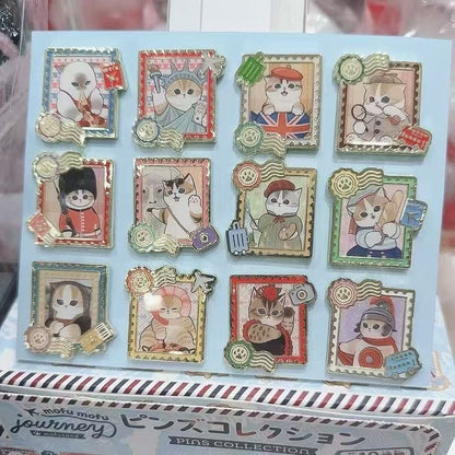Display of 12 Mofusand Journey travel-themed cat pin badge designs in decorative stamp-style frames.