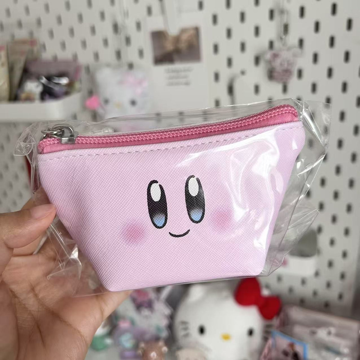 Pink Kirby face coin purse with a zip closure
