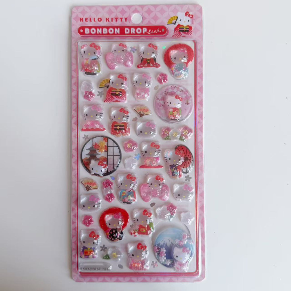 Hello Kitty BONBON DROP Kimono 3D sticker sheet on a pink backing card with a red title strip, folding fans, parasols and Mount Fuji.