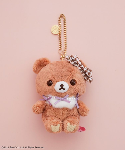 Chairoikoguma x Maison de FLEUR plush bag charm with a brown houndstooth head bow, lavender ribbons, white chest tuft and gold-coloured chain.