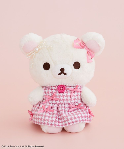 Korilakkuma x Maison de FLEUR S plush wearing a pink houndstooth dress with pink ribbons, a red button and pearl-like ear decoration.