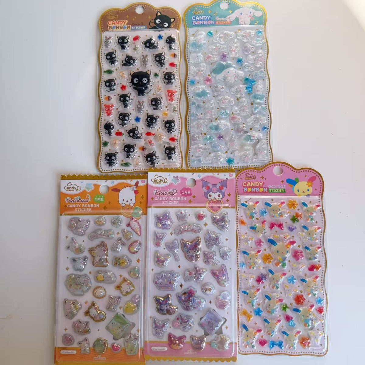 Five Sanrio Candy BONBON 3D sticker sheets displayed together, featuring Chococat, Cinnamoroll, Pochacco, Kuromi and Usahana in colourful packaging.